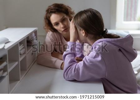 Caring mother talking to stressed unhappy adolescent daughter, helping in difficult life situation, giving advices against bullying in school or solving psychological problem, child protection concept Royalty-Free Stock Photo #1971215009