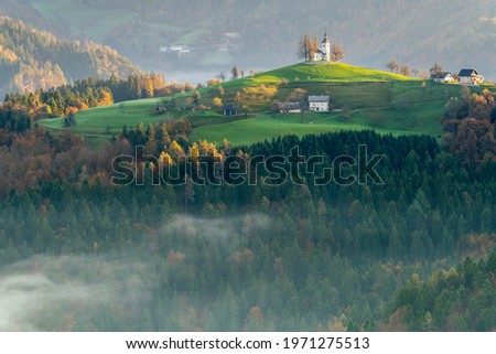 The Church of St. Tomaz (St. Thomas) on top of a hill at a beautiful sunrise in the fall, near Skofja Loka in the Upper Carniola region of Slovenia.