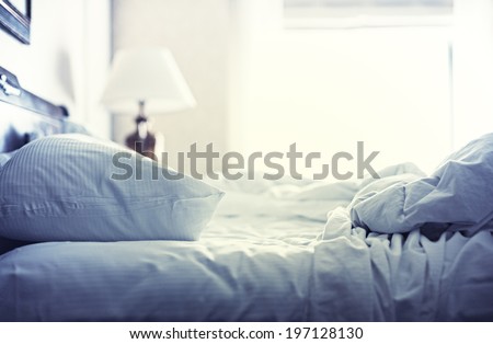 Blue themed bed sheets and pillows messed up after nights sleep. Royalty-Free Stock Photo #197128130