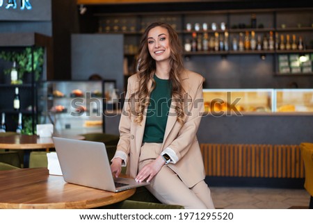 Business Woman Restaurant Owner Use Laptop In Hands Dressed Elegant Pantsuit Sitting On Table In Restaurant With Bar Counter Background Caucasian Female Business Person Indoor