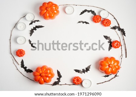 Halloween background, orange decorative plastic pumpkin black paper bat round candle white cardboard Thanksgiving greeting card pattern