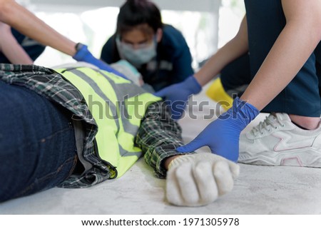 First aid team take a pulse for check injuries and Considered for all trauma incidents of worker in work, Loss of feeling or loss of normal movement. First aid training to transfer patient. Royalty-Free Stock Photo #1971305978