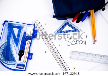 School supplies spread out on a spiral notebook.