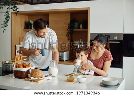 Happy family enjoying while having breakfast together in the morning at home.  Royalty-Free Stock Photo #1971349346