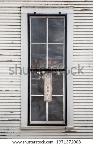 Old store window with a closed sign in the window in Texas