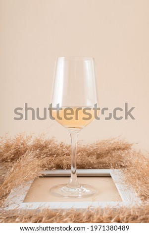 Refreshing white wine with beige summer pampas grass in white frame.