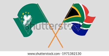 Crossed and waving flags of Macau and Republic of South Africa
