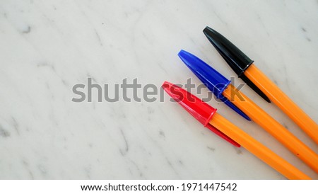 the 3-color ball point pen on the table Royalty-Free Stock Photo #1971447542