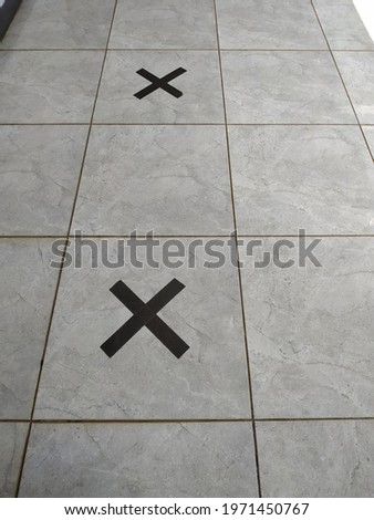 floor with a cross to keep your distance
