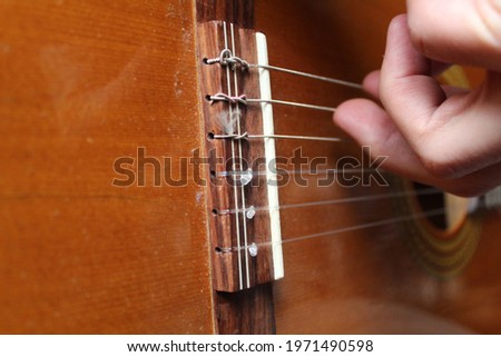 A closeup of a hand playing on a guitar