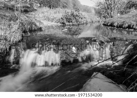 Long exposure of the Weir Water river  flowing through the valley at Robbers Bridge in Exmoor National Park