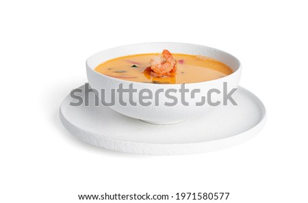 Soup with shrimps in a white deep dish isolated on a white background. Thai soup with seafood. Thai tom yum soup. High quality photo