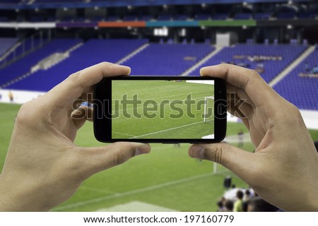 tourist takes a picture with his mobile of the football stadium