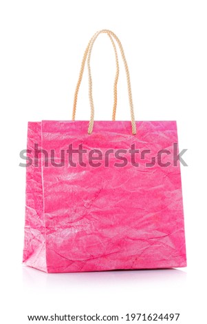 Pink nacre gift bag with raised handles. Package is made of crepe paper. Consumer pack ready for logo design. Advertising and branding. Isolated on a white background.