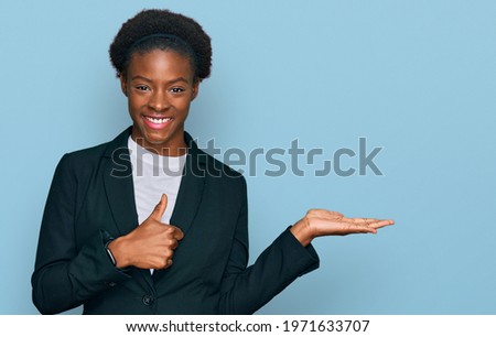 Young african american girl wearing business clothes showing palm hand and doing ok gesture with thumbs up, smiling happy and cheerful 