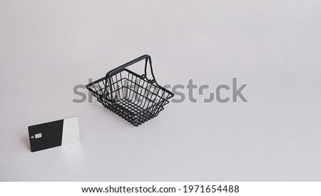 Minimal composition, credit card with shopping cart on the gray. Shopping online,  e-commerce lifestyle concept.