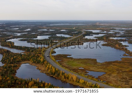 A road weaving between lakes in Western Siberia, air view. An aerial view of the road along lakes’s shores.