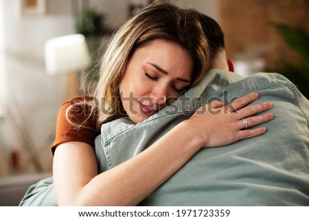 Young man having a problem. Wife comforting her sad husband. Royalty-Free Stock Photo #1971723359