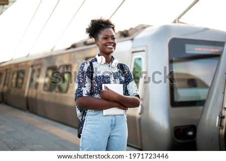 Young woman holding digital tablet. Beautiful african woman traveling around the city.	