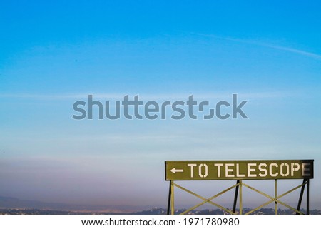 A "To Telescope" sign against a sunset background at the Griffith Observatory
