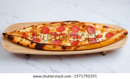 Turkish pizza. Sucuk pide on wooden tray isolated on white. Sausage pide.