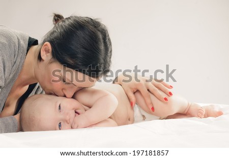 mother kissed her little baby, close-up on white background