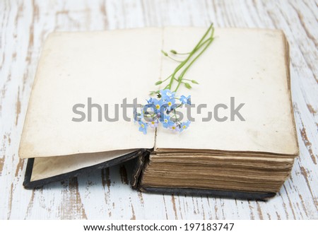 Bunch of forget-me-nots flowers and very old book