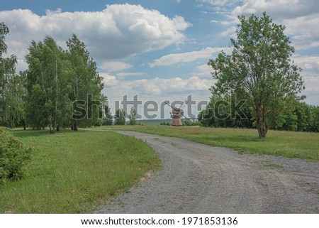 Summer landscape. A country road and a mill. Stock photo
