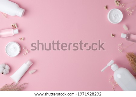 Cosmetic background with skin care products on pink. Flat lay, copy space