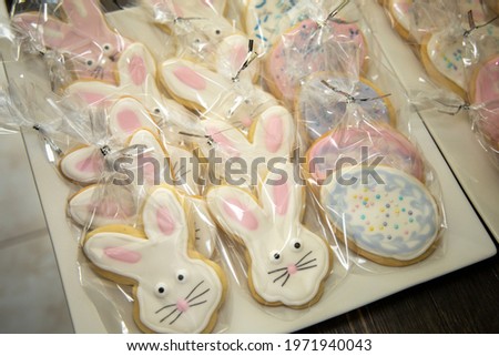 View of Easter bunny and egg cookies individually wrapped on a white platter.