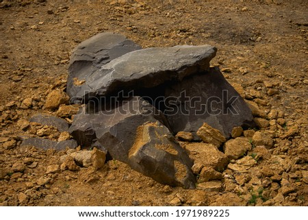 large gray stones lie on yellow clay 