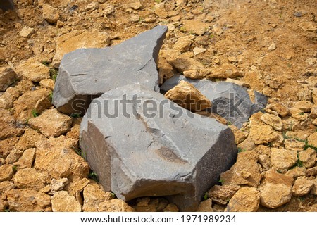large gray stones lie on yellow clay 