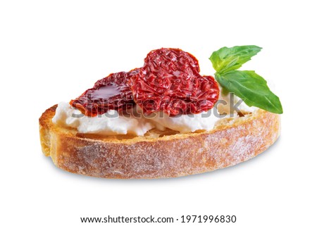 Ricotta dried tomato Basil bruschetta on a white isolated background. toning. selective focus Royalty-Free Stock Photo #1971996830