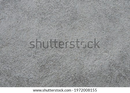 The texture of a gray surface covered with a mixture of sand and cement. Finishing works of building elements. Selective focus.