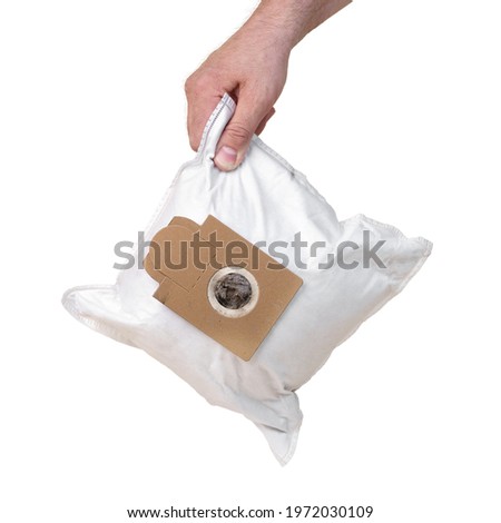 Male hand holds a used dust bag of a vacuum cleaner full of dirt isolated on the white background Royalty-Free Stock Photo #1972030109