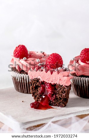 Chocolate cupcakes with raspberry cream and fresh raspberries