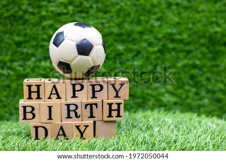 Soccer ball with happy birthday are on green grass