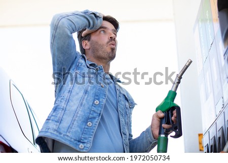 man in shock with gas price Royalty-Free Stock Photo #1972050734