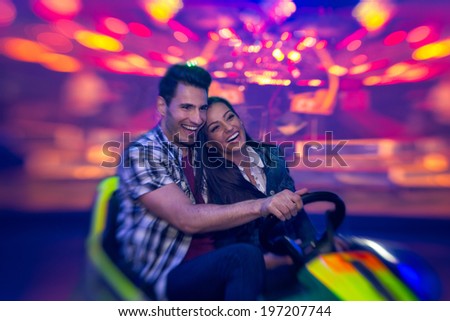Young smiling couple having a ride on a ferris wheel Royalty-Free Stock Photo #197207744