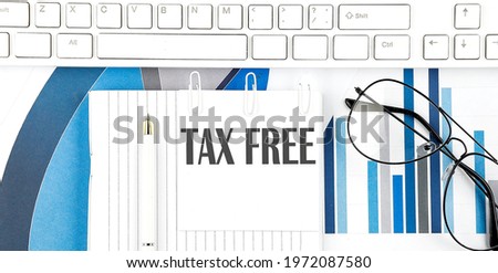 Office desk table with keyboard, chart,glasses and pen. Top view text TAX FREE