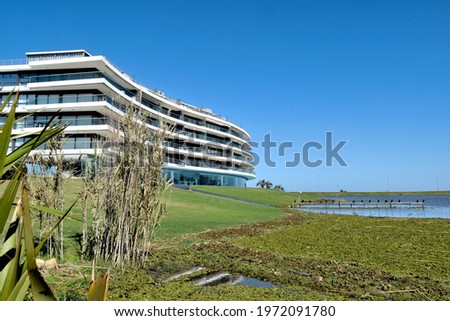 Photography of a beautiful lagoon, its coast and a white and blue building 