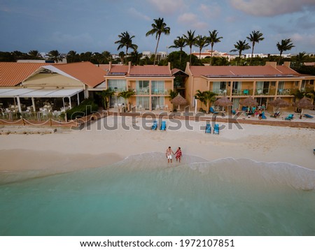 Aruba Caribbean couple man and woman mid age on vacation on the beach with palm trees on the beach