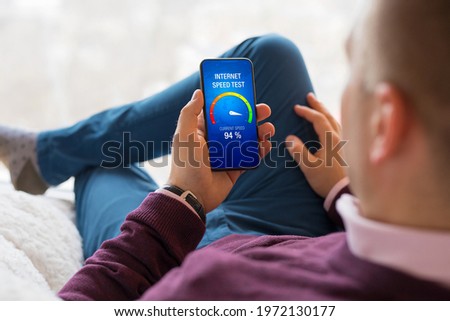 Man checking internet connection speed on his phone Royalty-Free Stock Photo #1972130177
