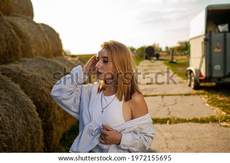Young Beautiful Blonde Woman in a straw hat relaxing On Dry Hay In Summer