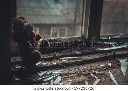 soft toy on the windowsill in the empty abandoned apartment Royalty-Free Stock Photo #197216726