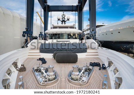Superyacht being hauled out for shipyard period with travel lift crane with blue sky Royalty-Free Stock Photo #1972180241