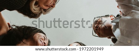 Happy diverse businesswomen huddling in the office Royalty-Free Stock Photo #1972201949