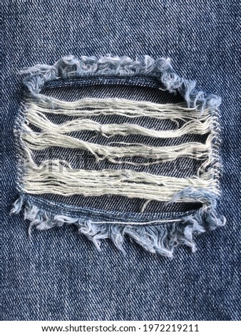 Close up torn hole jean texture background Royalty-Free Stock Photo #1972219211