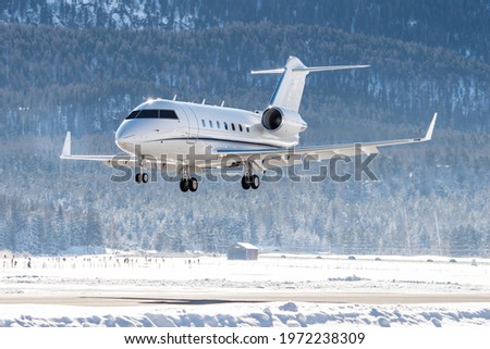 luxury business jet on short final at Samedan airport in the engadin valley. This airport is used by many business people to land on for their winter vacation in St.Moritz. Royalty-Free Stock Photo #1972238309