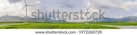 Wind power plant. green meadow with Wind turbines generating electricity Royalty-Free Stock Photo #1972260728